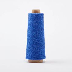 a spool of blue yarn on a white background