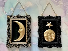 two framed pictures with moon and stars hanging from chains