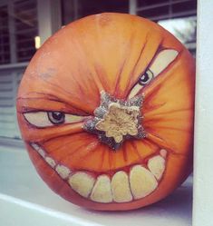 a pumpkin with an evil face painted on it's side and the mouth is open