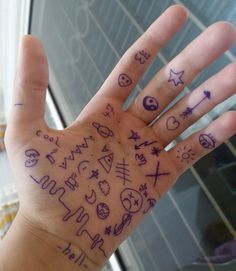 a person's hand with tattoos on it and writing all over the palm area