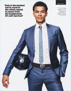 a man in a suit and tie holding a soccer ball