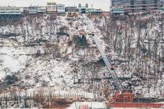 a fire truck is parked on the side of a snowy hill with buildings in the background