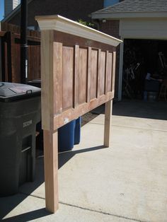 an image of a bed frame made out of wood and some trash canisters