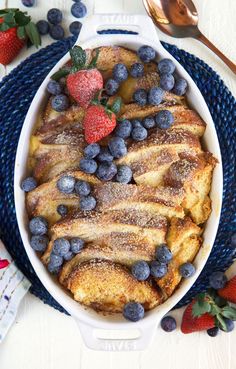 french toast with blueberries and strawberries in a casserole dish