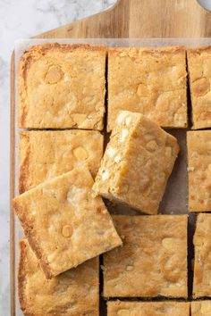 a cutting board topped with cut up squares of cake