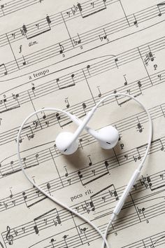 an earbud laying on top of sheet music