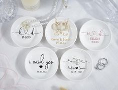 four personalized plates with names and hearts on them, sitting on a white tablecloth