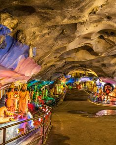 the inside of a cave filled with lots of colorful lights and people sitting on benches