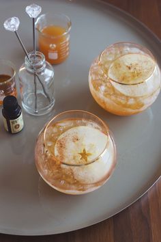 two glasses filled with liquid sitting on top of a plate