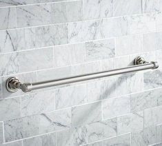 a white marble bathroom with stainless steel handles and handrails on the shower wall