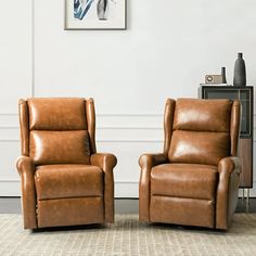 two brown recliners sitting next to each other on a rug in front of a white wall