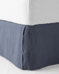 the bed is made with blue linens and white sheets