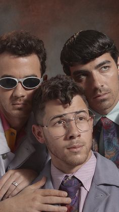 three men in suits and ties are posing for the camera