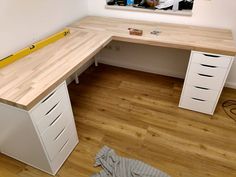 a white desk with drawers and a yellow tape on the wall next to it in a room