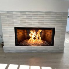 a fire is burning in a fireplace with white tiles