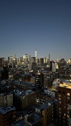 the city skyline is lit up at night, with skyscrapers in the foreground