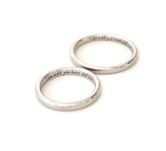 two silver rings with words on them