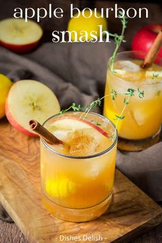 two glasses filled with apple bourbon smash on top of a cutting board