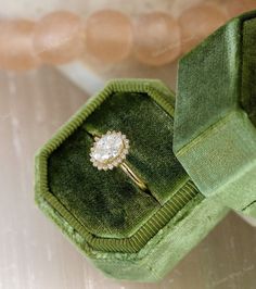 an engagement ring in a green velvet box