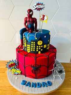 a spiderman themed birthday cake is displayed on a plate with the name sandro