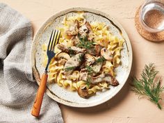 a white plate topped with pasta covered in mushrooms