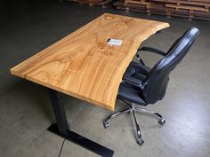 an office chair sits next to a wooden table with a name tag on the end