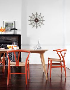 an orange table and four chairs in front of a fireplace