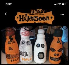 three bottles with faces painted on them and the words happy halloween are in front of each other