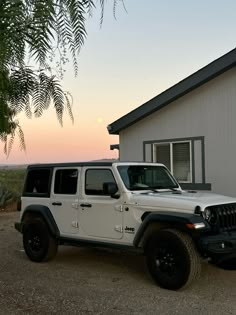 a white jeep parked in front of a house