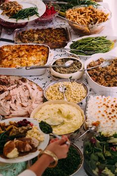 a table topped with lots of different types of food and dishes filled with meats