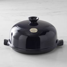 a black casserole dish sitting on top of a white counter