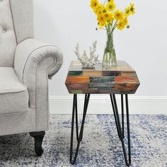 a vase with yellow flowers sitting on top of a wooden table next to a chair