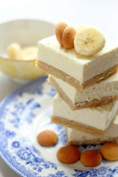 three pieces of cake sitting on top of a blue and white plate next to some nuts