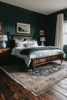 a bedroom with dark green walls and wood flooring has a large bed in the middle