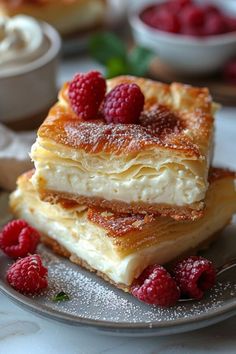 three desserts stacked on top of each other with raspberries in the middle