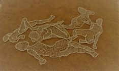 several pieces of crochet are laying on top of a brown surface with white thread