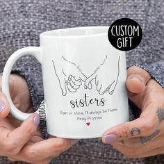 two hands holding a coffee mug with the words, custom gift for sisters on it