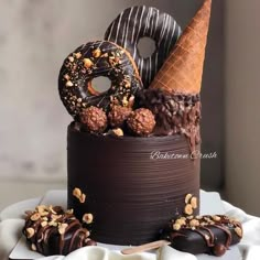 there is a chocolate cake with donuts and nuts on it