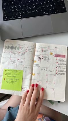 a woman's hand is on top of an open planner