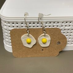 pair of earrings with yellow and white eggs on them