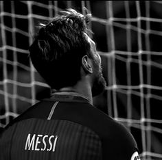 a man standing in front of a soccer net with the word messi on it