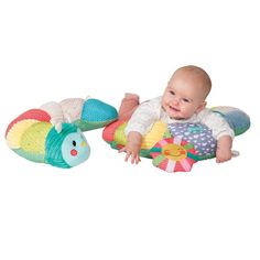 a baby laying on top of a toy in the shape of a fish and turtle