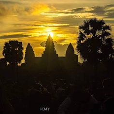 the sun is setting over an ancient temple