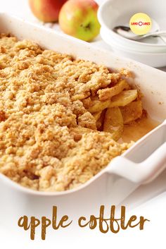 an apple crumbler in a white casserole dish next to some apples