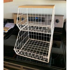 a white wire basket sitting on top of an oven