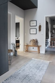 a living room filled with furniture and pictures on the wall next to a wooden table