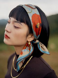 a woman with her eyes closed wearing a scarf around her head and looking off to the side