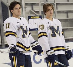 two young men standing next to each other on the ice