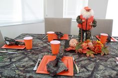 the table is set with orange plates and place settings for an autumn themed dinner party