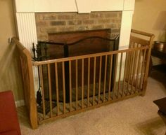 a living room with a fire place in the corner and a baby crib next to it